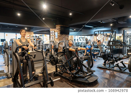 Young men and women exercising at the gym 108942978