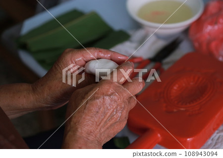 老婦人正在製作傳統的紅龜粿 老婦人正在製作傳統的紅龜粿 108943094