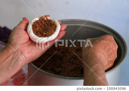 老婦人正在製作傳統的紅龜粿 老婦人正在製作傳統的紅龜粿 108943096