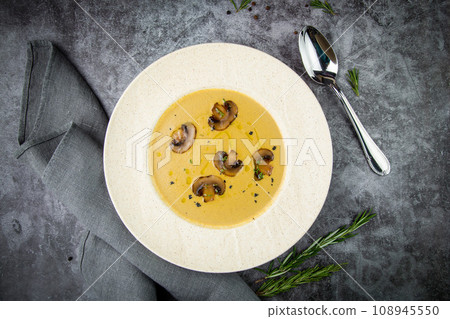 mushroom cream soup with herbs and champignons in a white plate 108945550