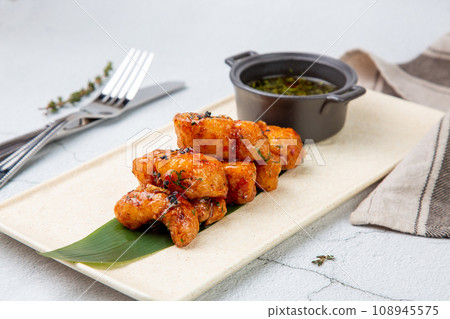 Slices of pike perch in sweet and sour sauce on a banana leaf 108945575