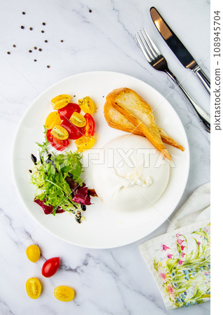 mozzarella with spinach, cherry tomatoes, wild berries and bread in a round plate top veiw mozzarella with spinach, cherry tomatoes, wild berries and bread in a round plate top veiw 108945704