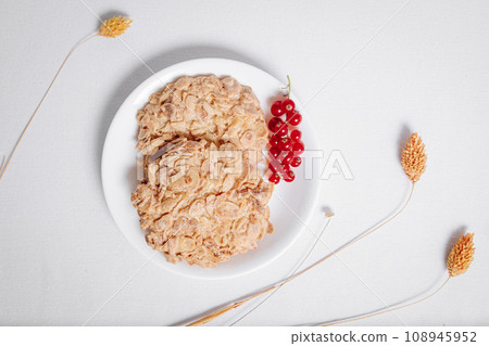 whole grain cookies with a sprig of red currants in a small white plate top view 108945952