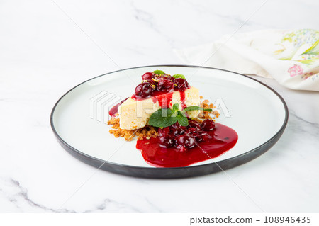 side view of cheesecake with juicy berries and mint on a white plate side view of cheesecake with juicy berries and mint on a white plate 108946435