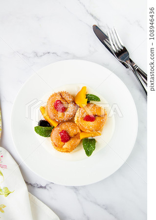 muffins with peach, raspberry, black berry and mint covered with powdered sugar, side view muffins with peach, raspberry, black berry and mint covered with powdered sugar, side view 108946436