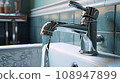 Faucet in the bathroom from which water flows. shallow depth of field 108947899