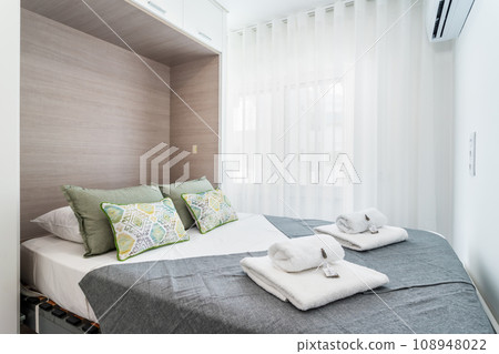 Double bed in the bright bedroom room interior furnishing furniture. Compact folding bed built into the wall. 108948022