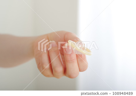 A woman's hand handing over a condom 108948489