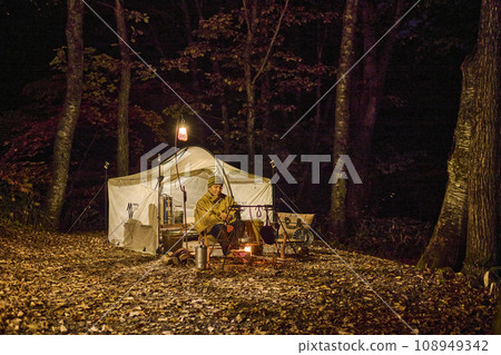 Solo camper making a bonfire at the campsite 108949342