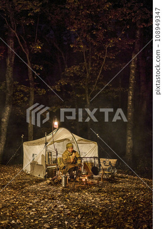 Solo camper making a bonfire at the campsite 108949347