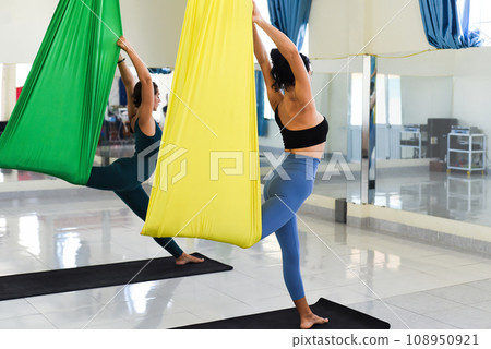 Young women making aerial or fly yoga pose Young women making aerial or fly yoga pose 108950921
