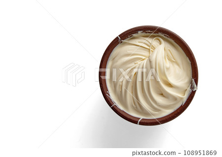 Butter whipped and twisted into a spiral in a brown clay bowl isolated on a background. Top view with copy space 108951869