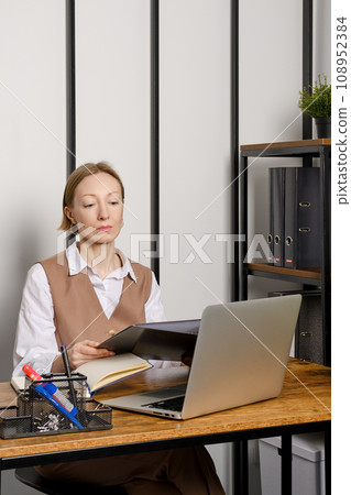 Adult woman holding in hands binder folder with files 108952384