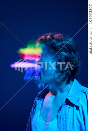Mood swings. Crazy young man shouting in mixed neon light illuminating futuristic, digital projector reflection. 108953807