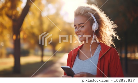Young Caucasian woman during a jogging workout in the autumn city park. 108953937