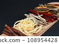 Salty snacks with beer and ale. Dried fish, squid, delicacies. Close-up on a black background. 108954428