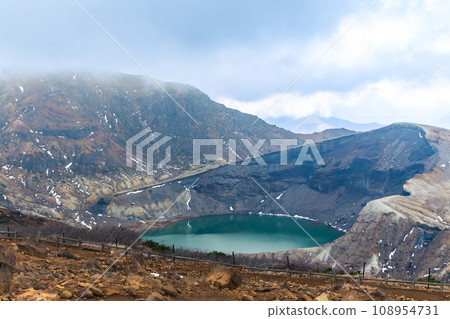 A mysterious volcanic lake seen through the clouds 108954731