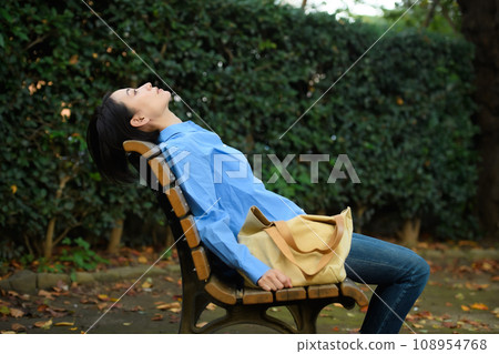 A worried woman sitting on a bench A worried woman sitting on a bench 108954768
