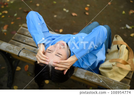 一個憂心忡忡的女人坐在長凳上 108954774