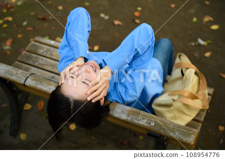 一個憂心忡忡的女人坐在長凳上 一個憂心忡忡的女人坐在長凳上 108954776