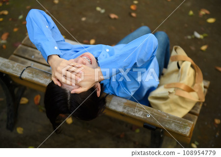 一個憂心忡忡的女人坐在長凳上 一個憂心忡忡的女人坐在長凳上 108954779