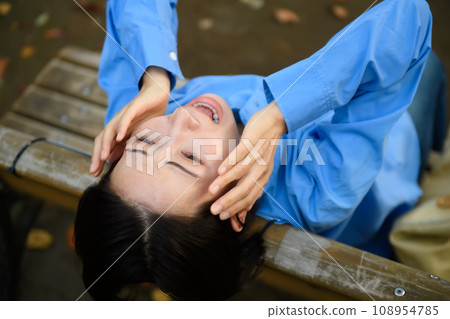 A worried woman sitting on a bench 108954785