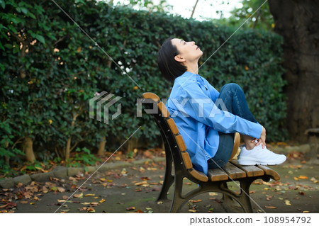 一個憂心忡忡的女人坐在長凳上 108954792