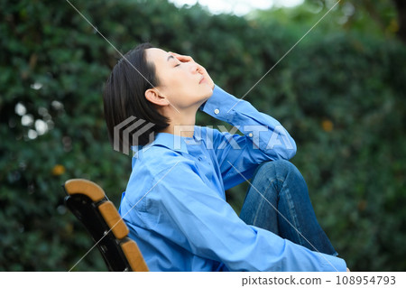 A worried woman sitting on a bench A worried woman sitting on a bench 108954793