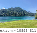 Huge mountain blue lake. Untouched wildlife of Europe. Majestic mountains covered with trees rise above the turquoise clean lake 108954811