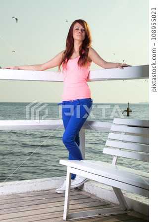 Attractive girl on pier. Young woman and sea 108955021