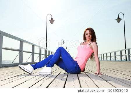 Attractive girl young woman on sea pier Attractive girl young woman on sea pier 108955040