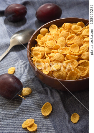Corn flakes in a bowl on the table with fruits Corn flakes in a bowl on the table with fruits 108955282