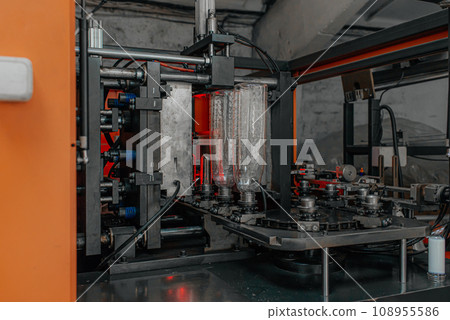 The preform shape of PET bottle in the blowing mold machine. The operation of PET bottle processing by blowing process with the blowing mold. The preform shape of PET bottle in the blowing mold machine. The operation of PET bottle processing by blowing process with the blowing mold. 108955586