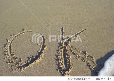 Lettering ok on sand sunrise background sea, beach dawn wave Lettering ok on sand sunrise background sea, beach dawn wave 108956016
