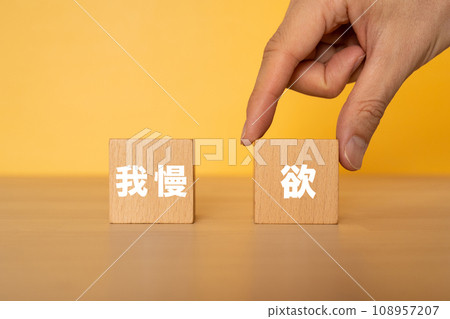 一隻手抓住一塊寫著「貪婪」的方塊 108957207