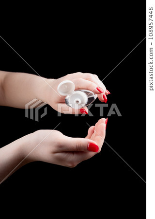 A young woman pours hand sanitizer gel into her palm. A young woman pours hand sanitizer gel into her palm. 108957448