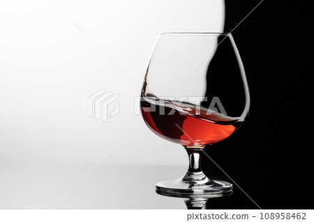 Splash of brandy in a snifter glass. 108958462