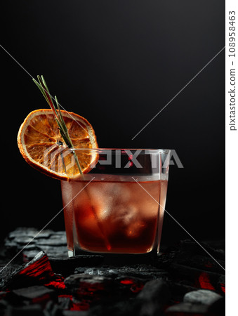 Old-fashioned cocktail with whiskey, ice, orange, and rosemary. Old-fashioned cocktail with whiskey, ice, orange, and rosemary. 108958463
