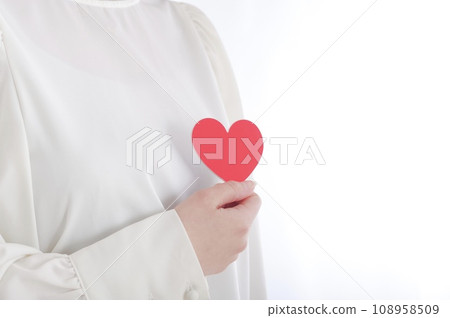 A woman holding a heart object on her chest 108958509