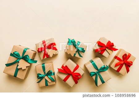 Colored craft gift boxes with colorful ribbons on colored background. Collection of Christmas present boxes Colored craft gift boxes with colorful ribbons on colored background. Collection of Christmas present boxes 108958696