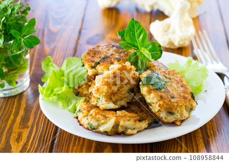 cooked vegetarian fried cauliflower cutlets, in a plate . 108958844