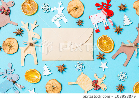 Top view of craft envelope on blue background made of holiday decorations and toys. Christmas ornament concept 108958879