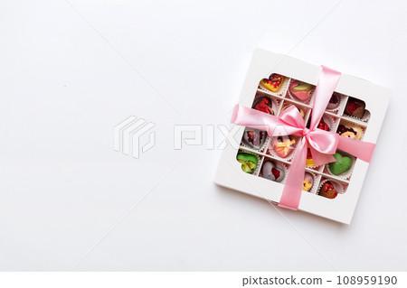 Box with sweet chocolate candies on color background, Various candy sweets. Valentines day gift box. Top view flat lay with copy space 108959190