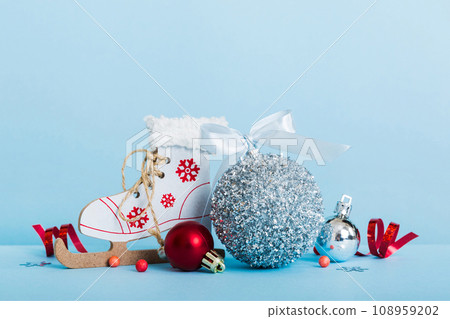 Christmas ball with skates on colored background. decoration bauble with ribbon bow with copy space 108959202