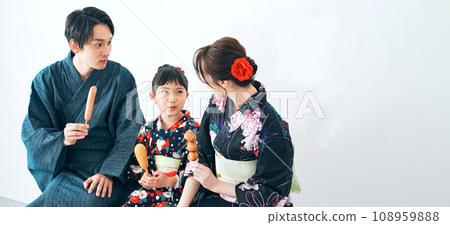 穿著浴衣吃街頭小吃的父母和孩子 穿著浴衣吃街頭小吃的父母和孩子 108959888