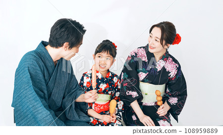 穿著浴衣吃街頭小吃的父母和孩子 穿著浴衣吃街頭小吃的父母和孩子 108959889
