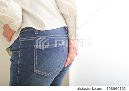 Young woman holding her butt with her hand 108960162