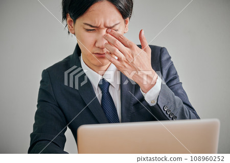 一名年輕男性上班族眼睛發癢,用手指揉眼睛 一名年輕男性上班族眼睛發癢,用手指揉眼睛 108960252