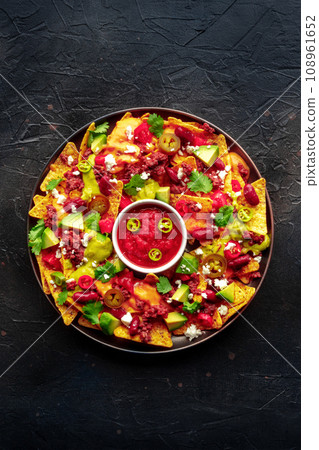 Loaded nachos. Mexican nacho chips with beef, overhead flat lay shot 108961652