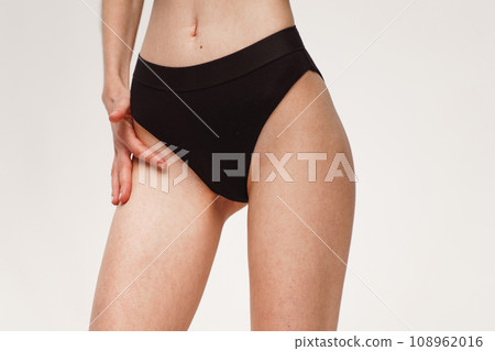 A woman with a beautiful feminine figure in black lingerie with overweight, cellulite and stretch marks. A woman with a beautiful feminine figure in black lingerie with overweight, cellulite and stretch marks. 108962016